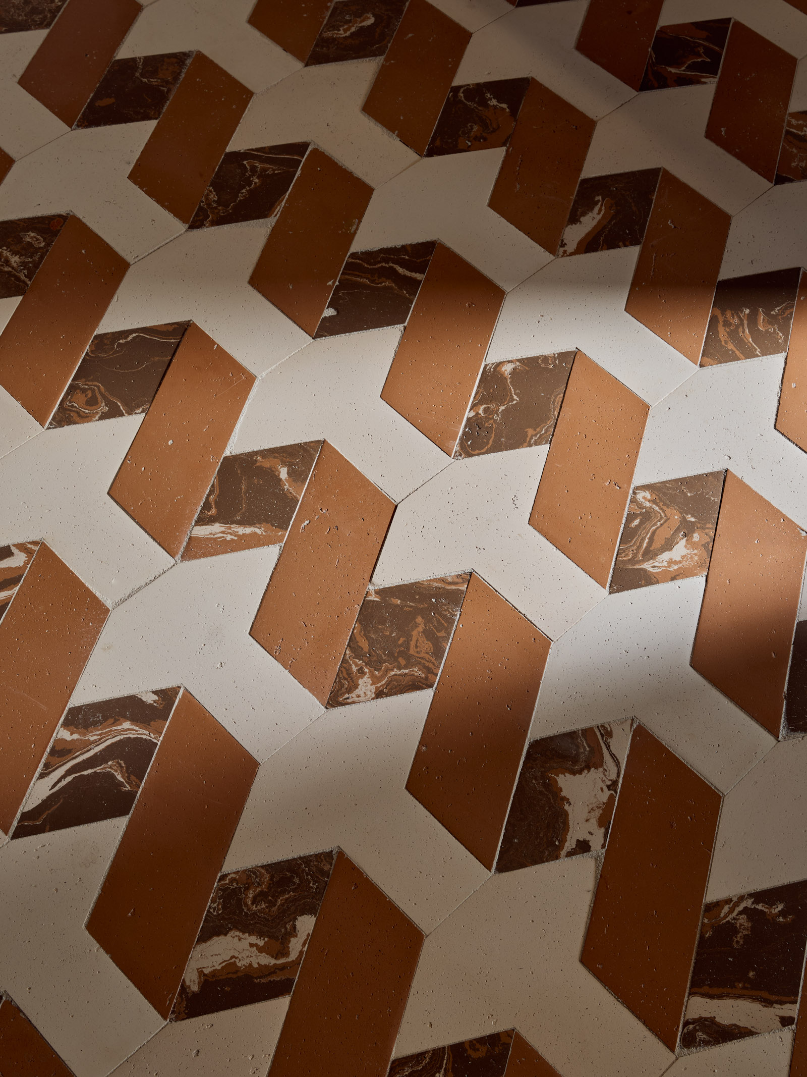 Pavimento in terracotta e marmo con disegno geometrico a zig-zag